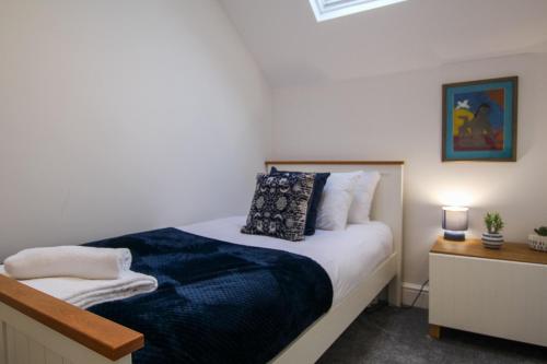 a bedroom with a bed with a blue blanket at Fairways View - Spacious Apartment - Sleeps 6 - Lovely Views - by Rework Accommodation in Hoylake
