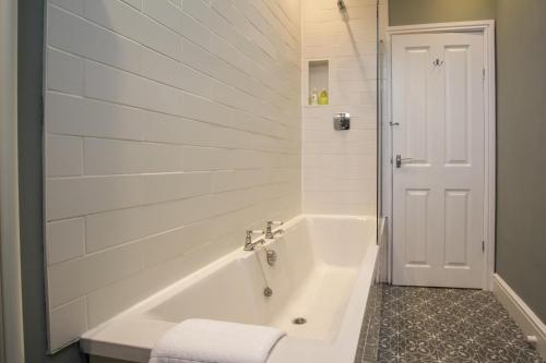 a white bathroom with a tub and a toilet at Fairways View - Spacious Apartment - Sleeps 6 - Lovely Views in Hoylake