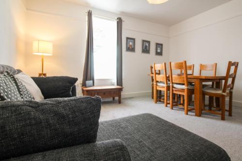 a living room with a couch and a table and chairs at Fairways View - Spacious Apartment - Sleeps 6 - Lovely Views - by Rework Accommodation in Hoylake