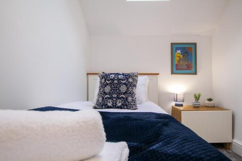 a bedroom with a bed with a blue blanket at Fairways View - Spacious Apartment - Sleeps 6 - Lovely Views - by Rework Accommodation in Hoylake