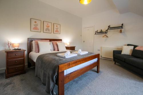 a bedroom with a bed and a couch in a room at Fairways View - Spacious Apartment - Sleeps 6 - Lovely Views - by Rework Accommodation in Hoylake