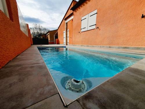 una piscina frente a un edificio en Villa H2o - Jacuzzi & Piscine chauffée en Le Barcarès