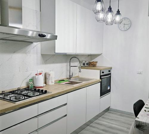 a white kitchen with a sink and a stove at Sempione Apartment in Lainate