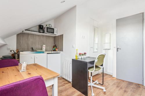 une cuisine et une salle à manger avec une table et des chaises violettes dans l'établissement Budget appart avec parking au centre-ville, à Charleville-Mézières