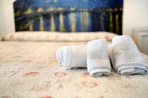 Dos toallas enrolladas encima de una cama en Actis2, borgo dei pescatori, en Cervo