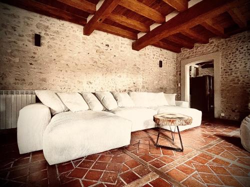 a living room with a white couch and a table at Le Clos de L'Olivier in Chaintreaux