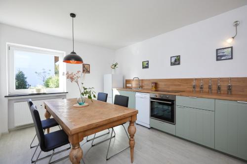 uma cozinha com uma mesa de madeira e uma sala de jantar em Ferienwohnung zum Hirschgarten em Krün