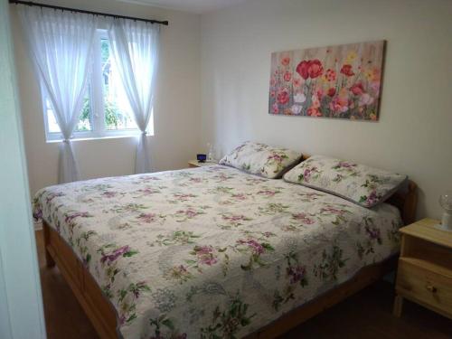 a bedroom with a bed with a floral comforter and a window at Guest house with Moroccan style in Gatineau 15 min from heart of Ottawa in Gatineau