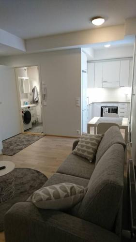 a living room with a couch and a kitchen at Studio Kakolanmäellä in Turku