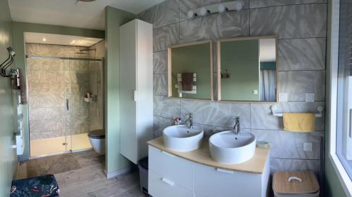 łazienka z dwiema umywalkami i prysznicem w obiekcie Cottage chaleureux avec vue sur lac w mieście Changey