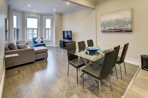 Plateau Prime Residence في مونتريال: غرفة معيشة مع طاولة وكراسي وأريكة