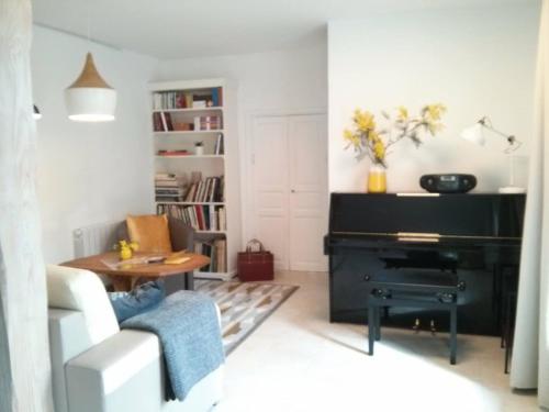 - un salon avec un piano et une table dans l'établissement La maison des créatifs, à Montdardier
