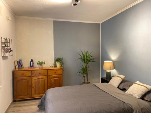 a bedroom with a bed and a wooden dresser at Appartement Ostend in Ostend