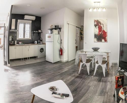 eine Küche und ein Wohnzimmer mit einem Tisch und einem Kühlschrank in der Unterkunft Pizarro 32 - A las puertas del campo talaverano in Talavera de la Reina