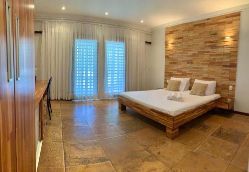 a bedroom with a bed and a brick wall at Pousada Refúgio Jardim de Canoa by Borboleta in Canoa Quebrada