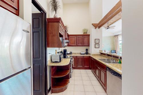 a kitchen with wooden cabinets and a refrigerator at Del Pacifico Condo C7 in Bejuco