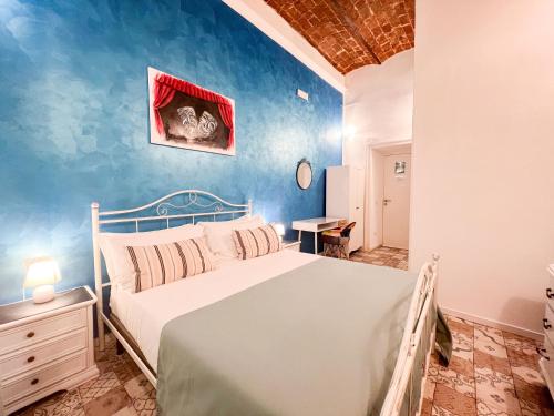um quarto com uma cama e uma parede azul em Suite Scarlatti em Nápoles
