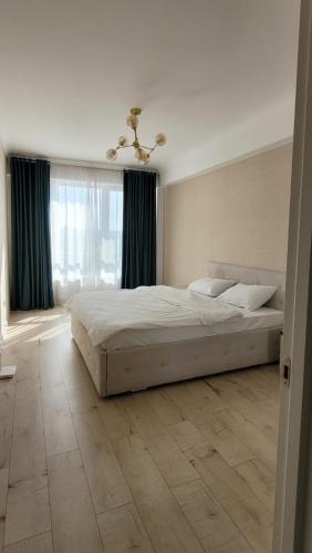 ein Schlafzimmer mit einem großen Bett und einem großen Fenster in der Unterkunft Сан-Марко in Chişinău