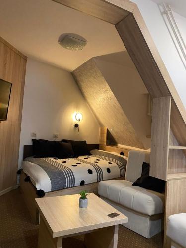 a hotel room with two beds and a couch at Apartment Maja Konaci in Kopaonik