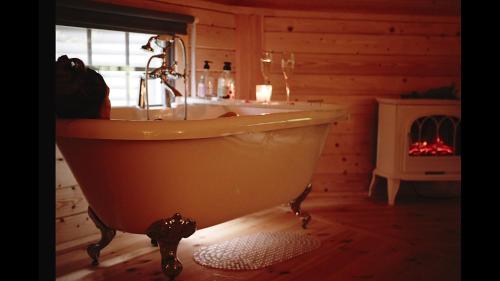 Habitación con baño con bañera y lavabo. en Aos Sí Lodges en Ballachulish