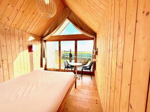 een slaapkamer met een bed en een tafel in een kamer bij Lushna 11 Lux Suite at Lee Wick Farm Cottages & Glamping in Clacton-on-Sea