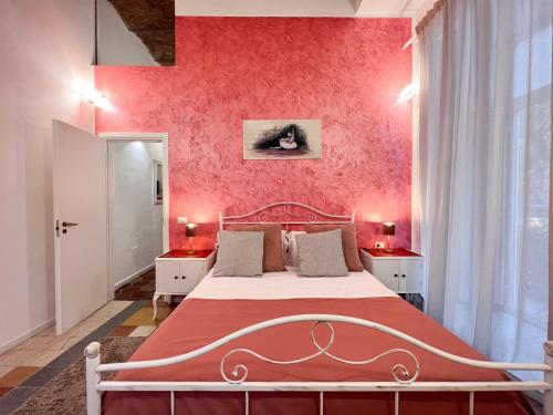 - une chambre avec un lit et un mur rose dans l'établissement Suite Scarlatti, à Naples