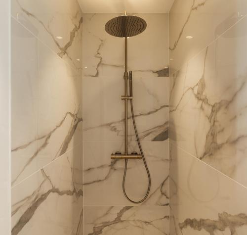 a bathroom with a shower with white marble walls at L'Ardoise, L'Anjou, La Vigne et La Loire in Angers