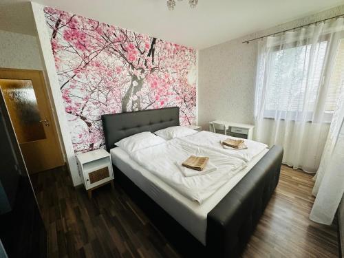 1 dormitorio con 1 cama con pared de flores en KVARTYRA 11 DE-LUX, en Jesenice