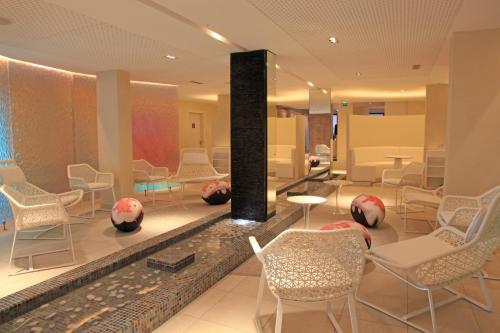 - un hall avec des chaises, des tables et une cheminée dans l'établissement Radisson Blu Resort & Spa, Ajaccio Bay, à Porticcio