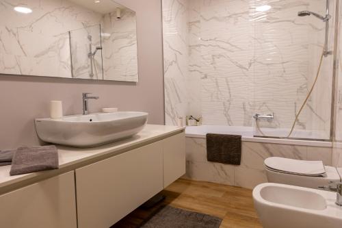 a bathroom with a sink and a toilet and a tub at Casetta al centro in Trento