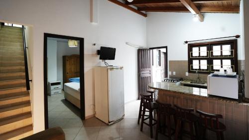 eine Küche mit Kühlschrank und eine Küche mit Bett in der Unterkunft Residencial Beija Flor Apartamento 23 in Bombinhas