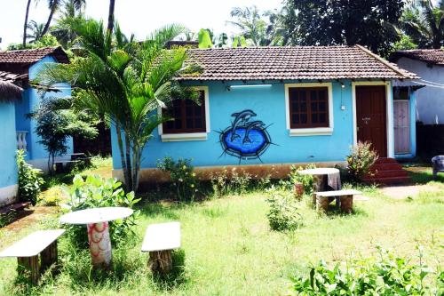 ein blaues Haus mit einem Tisch und Bänken im Hof in der Unterkunft Caasa De Nirvana by OceanSide 4 Guest in Velha Goa