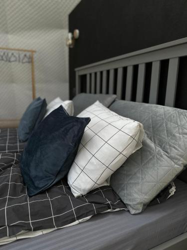 a bed with four pillows on top of it at The Frog Glamping in Horezu