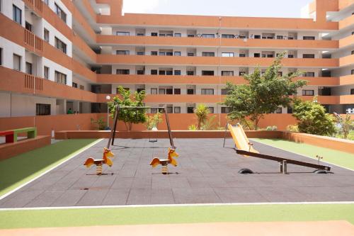 a playground in front of a large building at 3 bdr cozy apt in Condominio Mi, Palmarejo Grande in Praia
