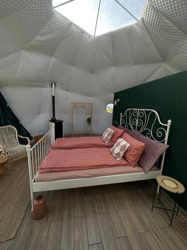 una camera con un grande letto in una tenda di The Frog Glamping a Horezu