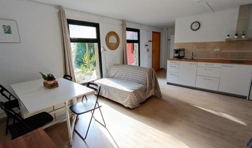 ein Schlafzimmer mit einem Bett und einem Tisch sowie eine Küche in der Unterkunft Casa de invitados in La Torre de Claramunt
