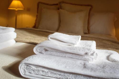een stapel handdoeken bovenop een bed bij Philippe chateau in Krepeni