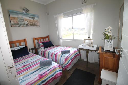 a bedroom with two beds and a window at Du Bantry 14 in Uvongo Beach