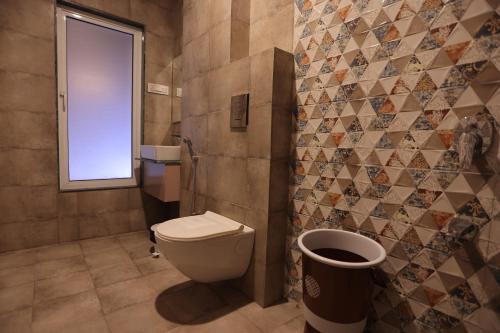 a bathroom with a toilet and a window at The Grand Uddhav- a boutique hotel in Udaipur