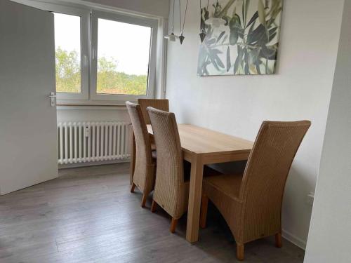 jadalnia z drewnianym stołem i krzesłami w obiekcie Geräumige Wohnung in ruhiger Lage in Gütersloh mit Netflix w mieście Gütersloh