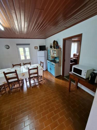 a living room with a table and chairs and a kitchen at Casa de Cabecinho- Albufeira do Azibo in Bragança