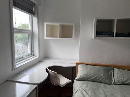a bedroom with a bed and a desk and a window at 36 park road house in Nottingham