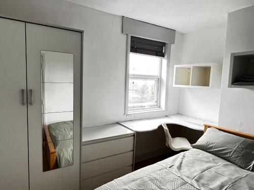 a bedroom with a bed and a window and a mirror at 36 park road house in Nottingham