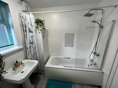 a white bathroom with a tub and a sink at Central City Castle Apartment with FREE parking in Nottingham