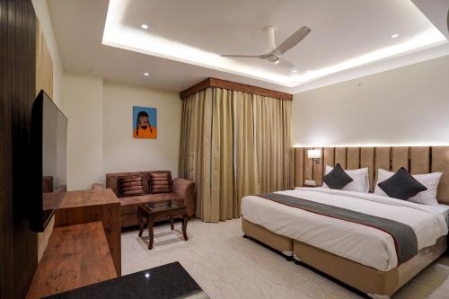 um quarto de hotel com uma cama e uma secretária em OYO Collection O Hotel Sg Inn em Greater Noida