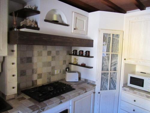 cocina con armarios blancos y fogones en Apartment in the heart of Tuscany, en Montelupo Fiorentino