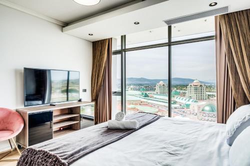 1 dormitorio con cama grande y ventana grande en Belina - Crystal Towers Presidential Penthouse, en Ciudad del Cabo