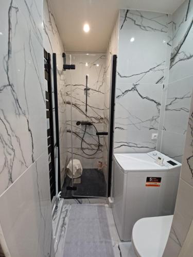 a white bathroom with a shower and a toilet at StudioPARIS17 in Paris