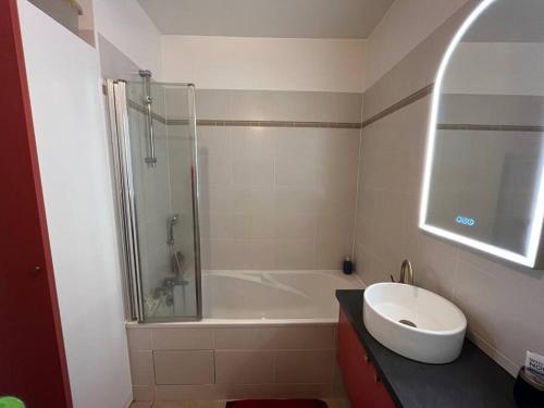 a bathroom with a tub and a sink and a shower at Appartement, piscine, Garches in Garches
