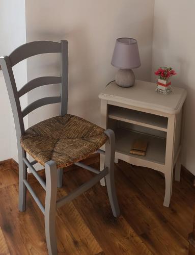 une chaise assise à côté d'un bureau avec une lampe dans l'établissement Le Gite de Maminou classé 3 étoiles, à Saint-Julien-en-Beauchêne